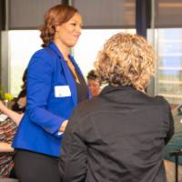 woman in blue jacket shakes hands